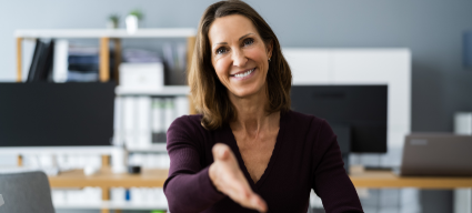 How the Empowerly platform helps Sponsors (Image shows a woman sitting in an office setting, smiling and holding her hand out to shake)